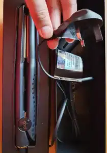 Persona sosteniendo el cable de poder de la plancha de pelo GHD Mini Styler