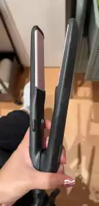 Plancha de pelo Philips negra en manos de mujer